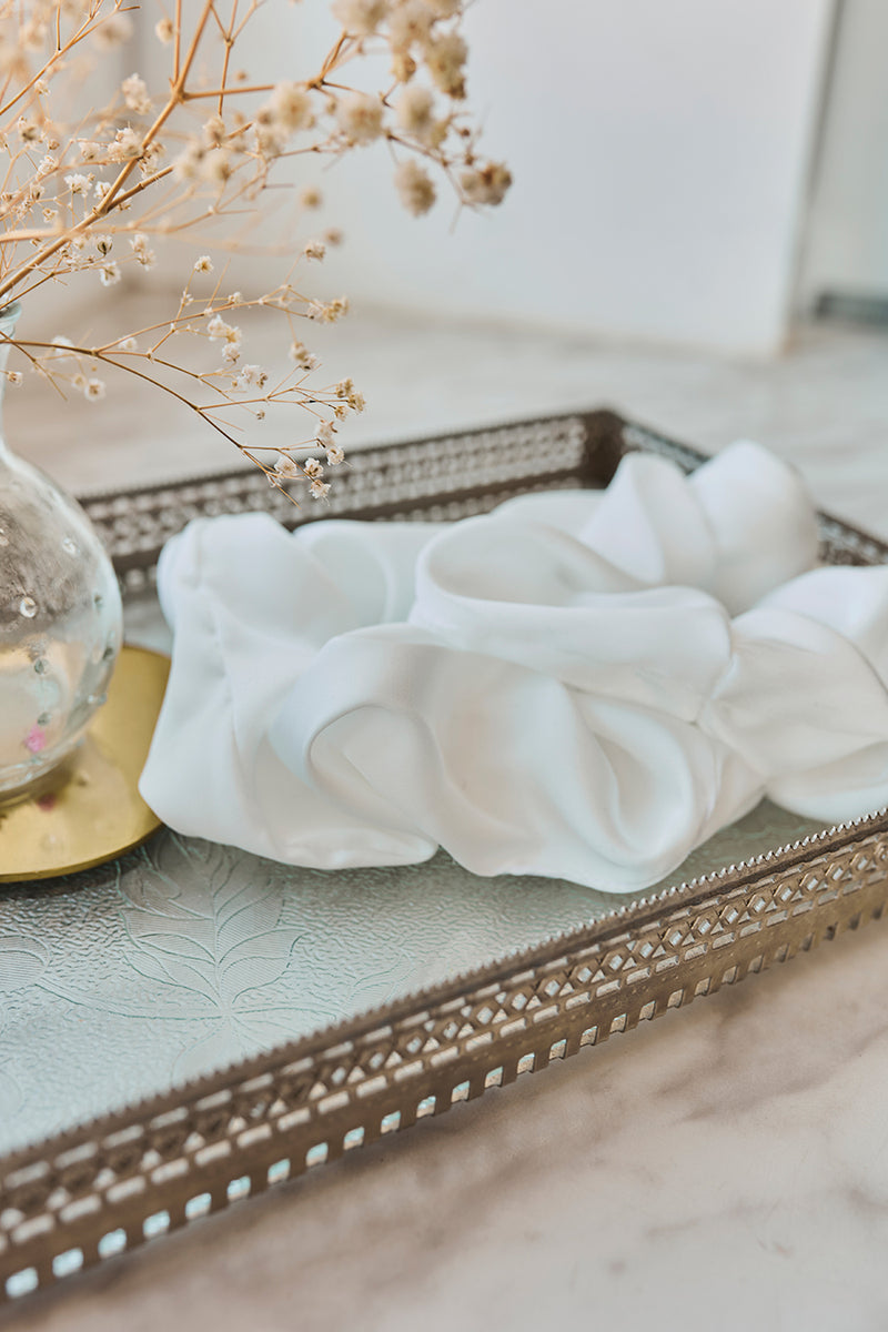 Biała gumka do włosów Franka K typu scrunchie, wykonana z delikatnej, błyszczącej satyny.