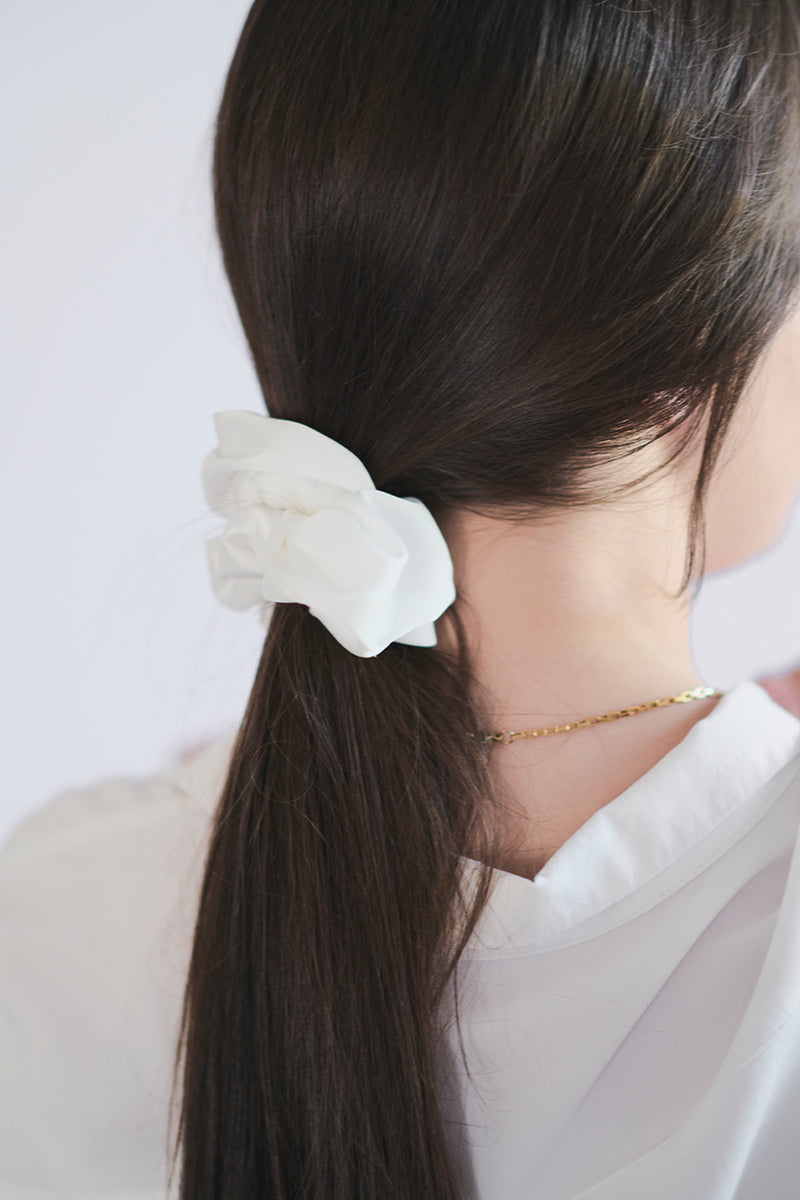 Biała gumka do włosów Franka K typu scrunchie, wykonana z delikatnej, błyszczącej satyny.