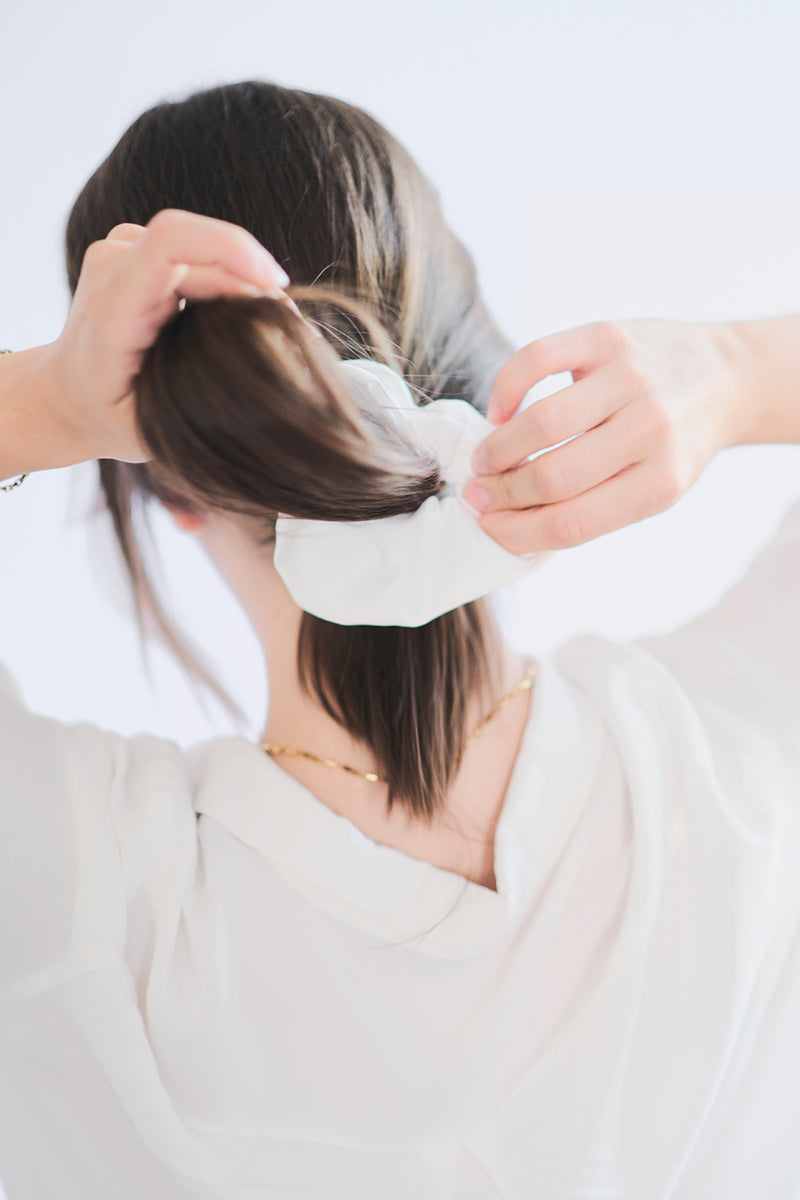 Biała gumka do włosów Franka K typu scrunchie, wykonana z delikatnej, błyszczącej satyny.