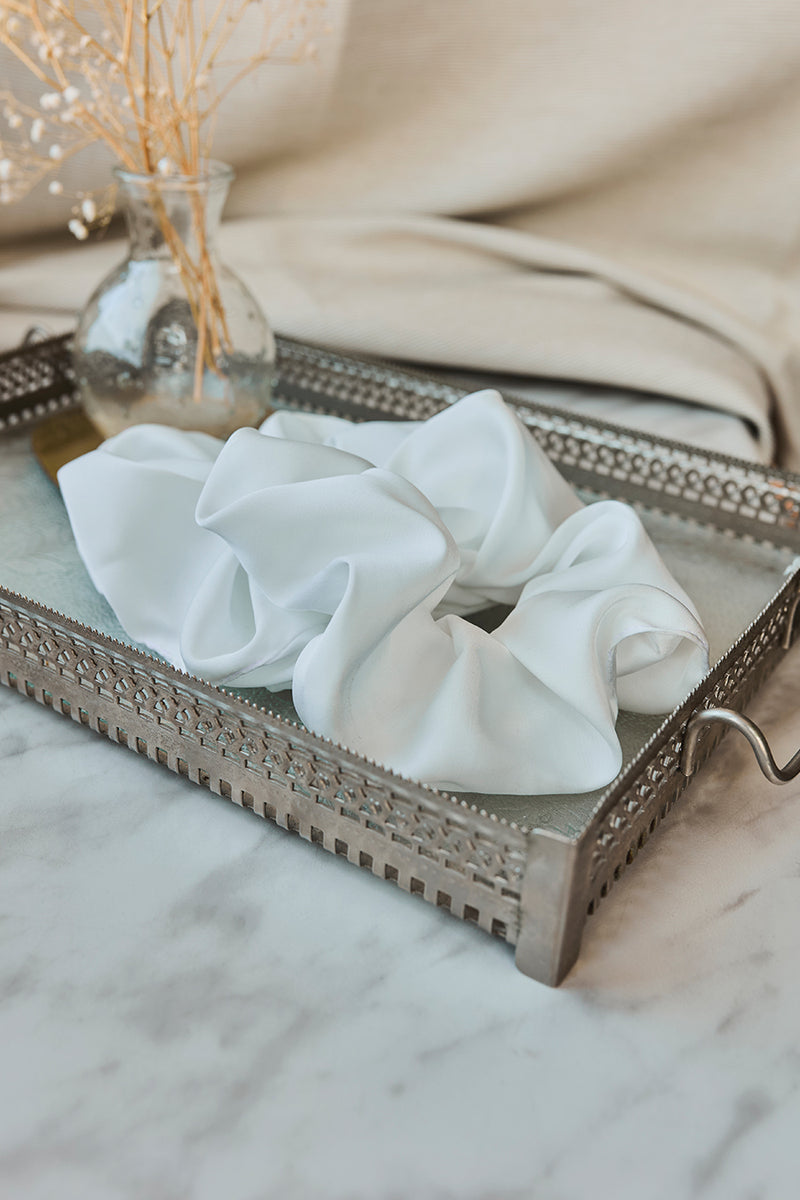 Biała gumka do włosów Franka K typu scrunchie, wykonana z delikatnej, błyszczącej satyny.