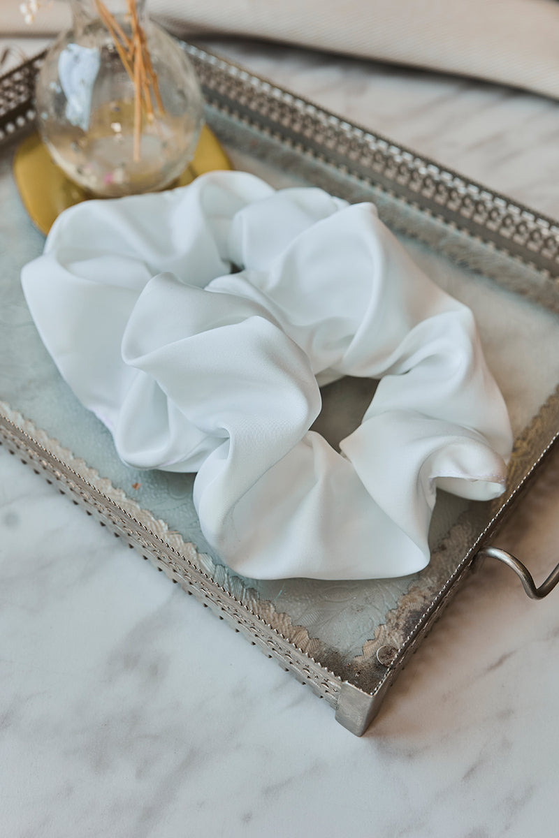 Biała gumka do włosów Franka K typu scrunchie, wykonana z delikatnej, błyszczącej satyny.