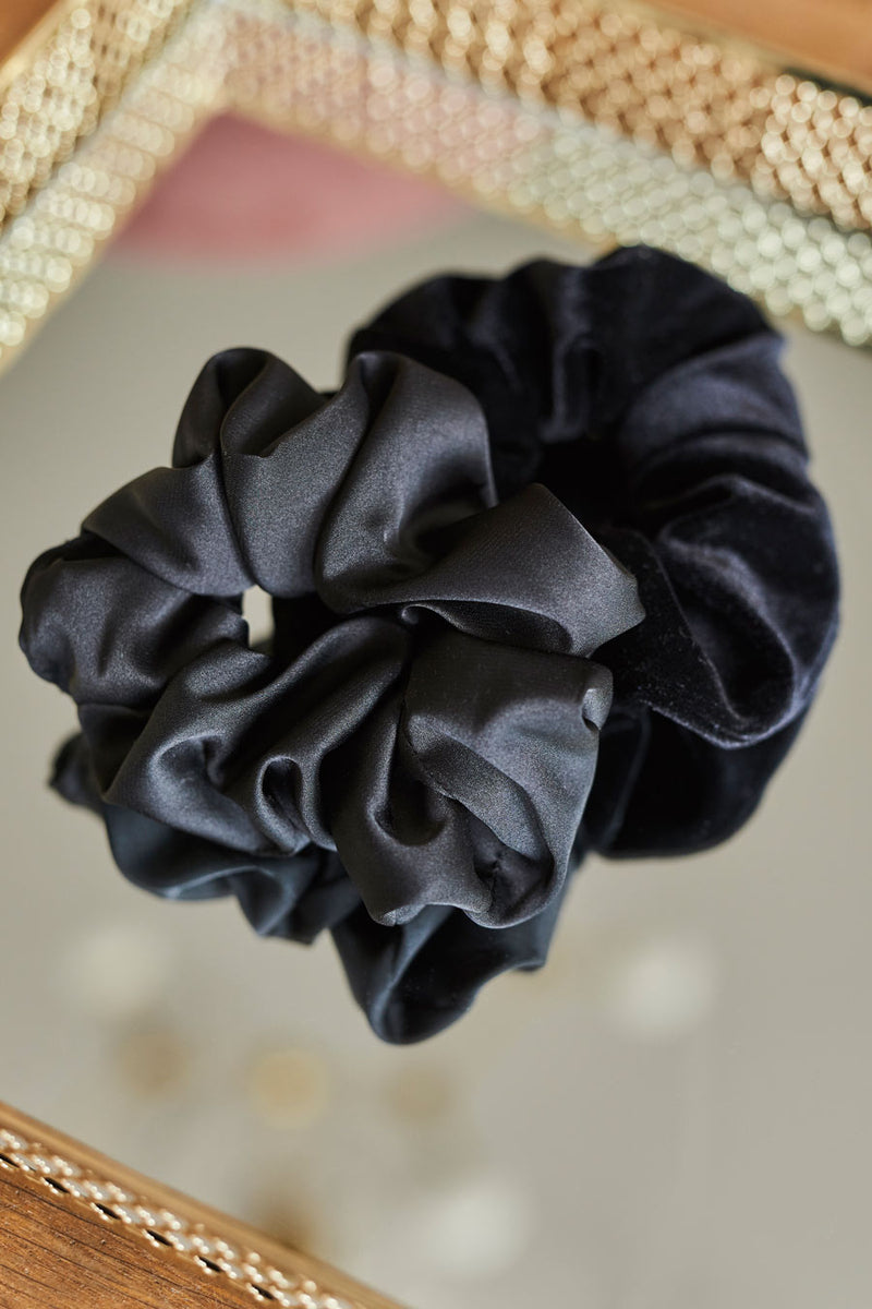 Czarna gumka do włosów Franka K typu scrunchie, wykonana z delikatnej, błyszczącej satyny.