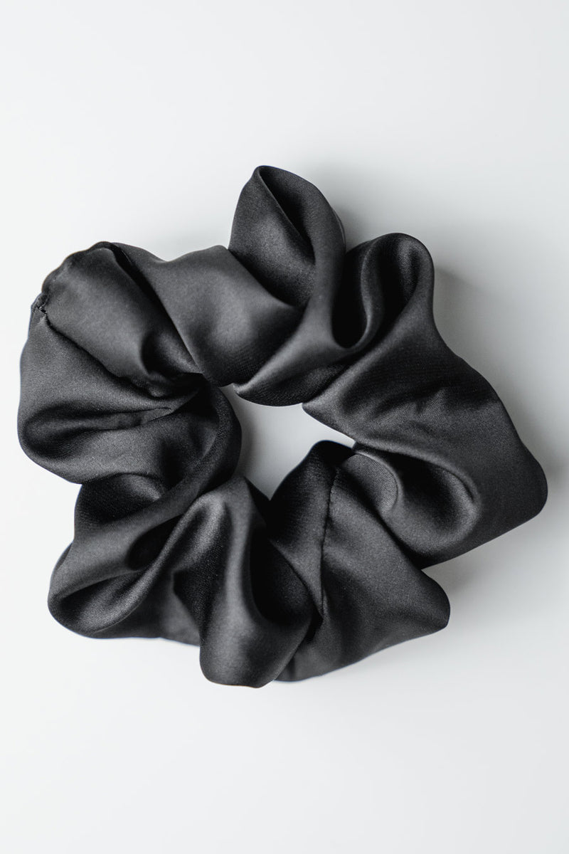 Czarna gumka do włosów Franka K typu scrunchie, wykonana z delikatnej, błyszczącej satyny.