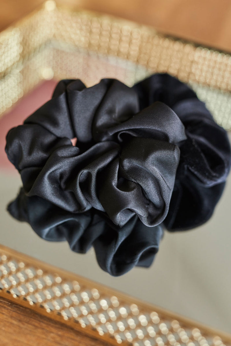 Czarna gumka do włosów Franka K typu scrunchie, wykonana z delikatnej, błyszczącej satyny.