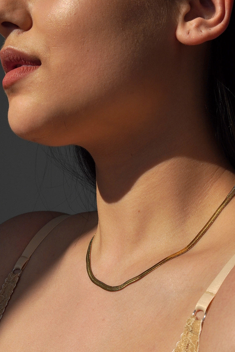 Naszyjnik Franka K model Vipera, typu żmijka, w złotym kolorze, o subtelnym połysku i eleganckim oplocie przypominającym wężową skórę.