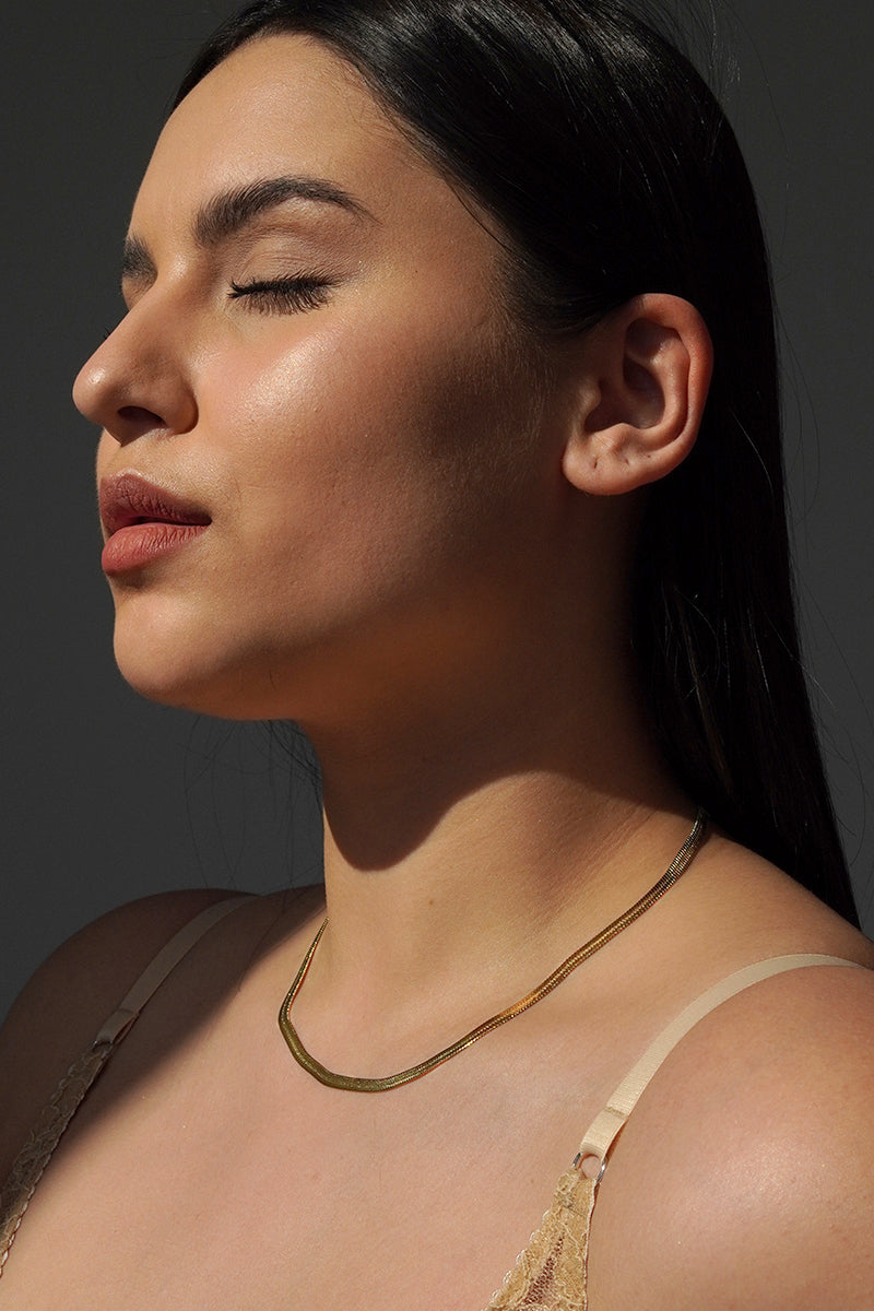 Naszyjnik Franka K model Vipera, typu żmijka, w złotym kolorze, o subtelnym połysku i eleganckim oplocie przypominającym wężową skórę.